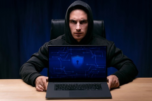 A Hacker Trying to Hack Through a Business Using His Laptop